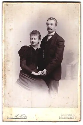 Fotografie J. Müller, Rumburg, Pragergasse 6, junges Ehepaar in dunkler Kleidung