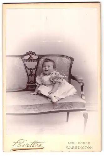 Fotografie Birtles, Warrington, Legh House, Portrait niedliches Kleinkind auf Sofa posierend