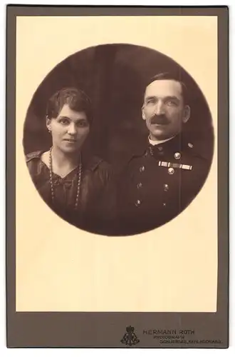 Fotografie Hermann Roth, Schliersee /Bayern, Portrait Ehepaar, Frau mit Perlenkette, Mann in Uniform mit Ordenspange