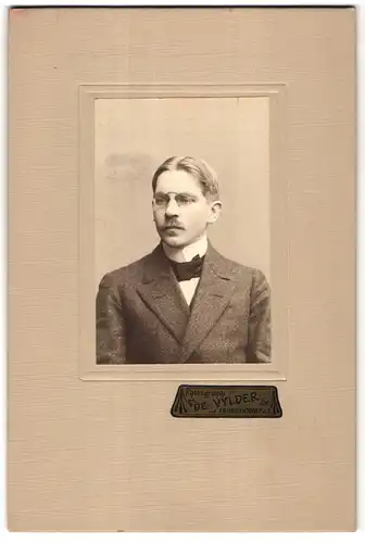 Fotografie De Vylder, Friedrichsdorf a.T., Portrait junger Mann mit Querbinder und Zwicker