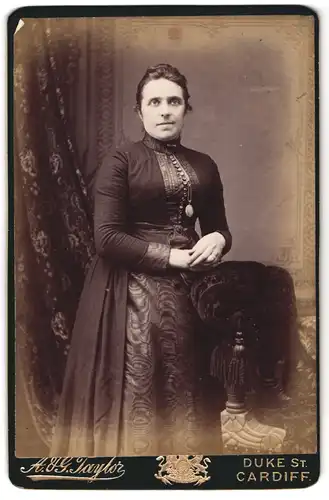 Fotografie A. & G. Taylor, Cardiff, Duke Street, Portrait Elegante Frau in tailliertem Kleid mit Brosche