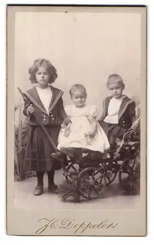 Fotografie Jb. Deppeler, Bern, Marktgasse 46, Portrait Kinder in einem Bollerwagen vor einer Studiokulisse