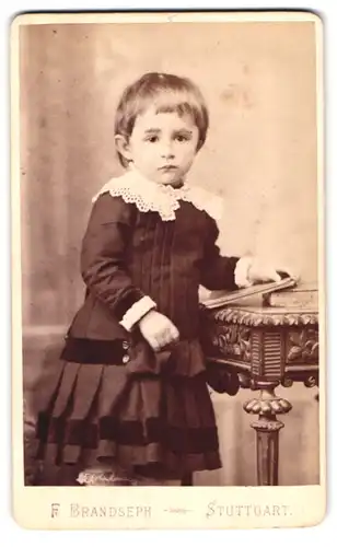Fotografie F. Brandseph, Stuttgart, Marienstrasse 36, Portrait kleines Mädchen in hübscher Kleidung mit Buch