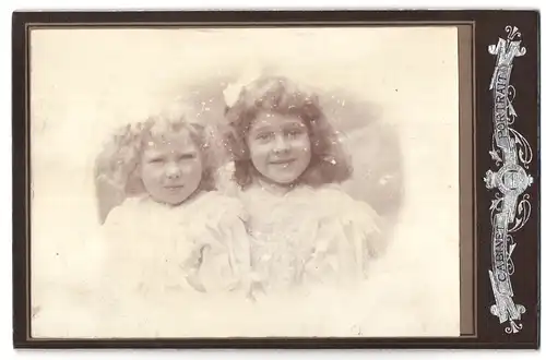 Fotografie unbekannter Fotograf und Ort, Zwei kleine Mädchen mit lockigen Haaren tragen weisse Kleider