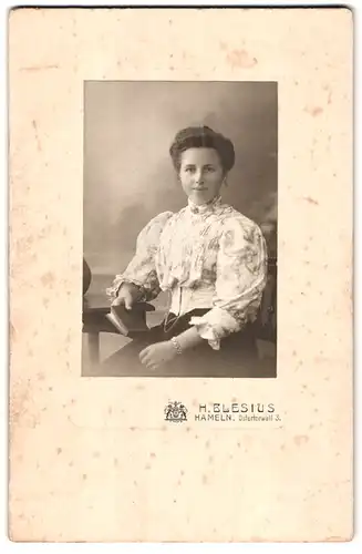 Fotografie H. Blesius, Hameln, Ostertorwall 3, Junge elegant gekleidete Dame mit Armband und Buch