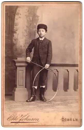 Fotografie Otto Johnsen, Döbeln, Breite Str. 331, Junger Bursche in Mantel mit seinem Spielreifen