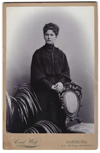 Fotografie Carl Wolf, Harburg, Junge Dame in verziertem Kleid mit langer Halskette und Ohrsteckern
