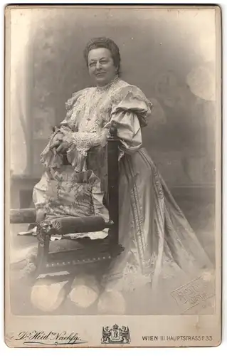 Fotografie Dr. H. Heid, Wien, Hauptstr. 33, Ältere Dame in aufwändig geschmücktem Kleid trägt eine Zwicker