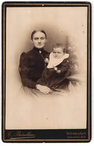 Fotografie C. Brändlein, Schweinfurt, Gymnasium-Str. 2, Junge Mutter mit Ohrsteckern mit Kleinkind mit Rassel