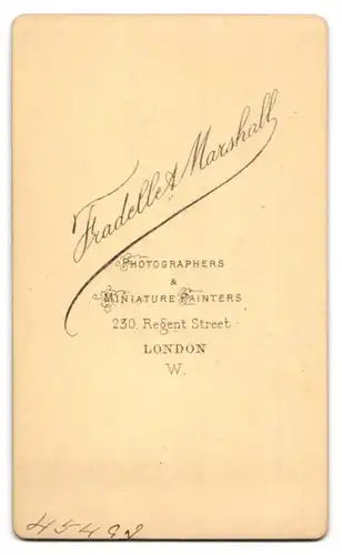 Fotografie Fradelle & Marshall, London, 230 & 246 Regent Street, Portrait einer eleganten Dame mit Buch am Tisch sitzend