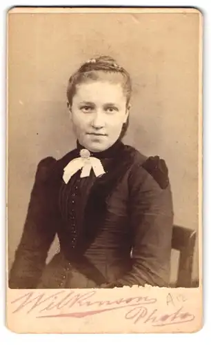 Fotografie Wilkinson, Huddersfield, Portrait bildschönes Mädchen mit Dutt und Schleife am Kragen