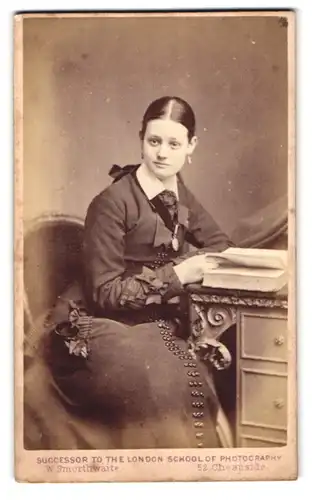 Fotografie W. Smorthwaite, London, 52 Cheapside, Portrait dunkelhaarigen junge Schönheit mit Buch am Tisch sitzend