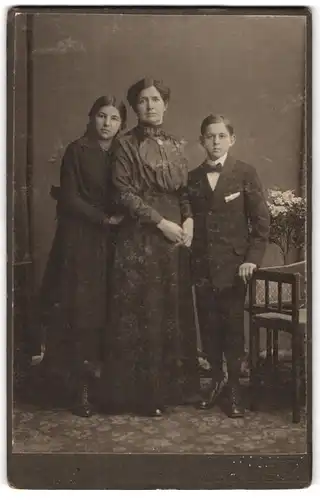 Fotografie Franz Hackenhost, Pirmasens, Junge mit Einstecktuch mit Mutter und Schwetser in dunklen Kleidern.