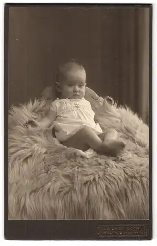 Fotografie Samson & Co, Barmen, Wertherstr. 20, Süsses Baby in weissem Kleid auf Fell
