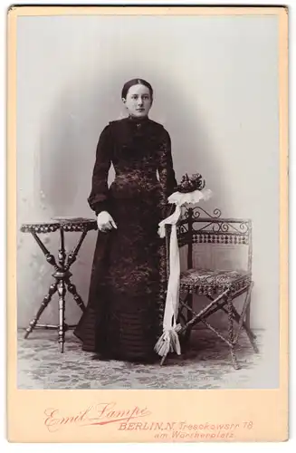 Fotografie Emil Lampe, Berlin, Treschkostr. 18, Junge Frau mit Mittelscheitel in schwarzem Kleid mit Blumenbouqet