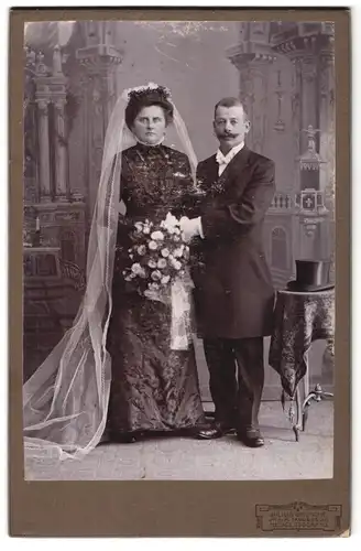 Fotografie Julius Grusche, Neugersdorf, Portrait bürgerliches Paar in Hochzeitskleidung mit Schleier & Blumenstrauss