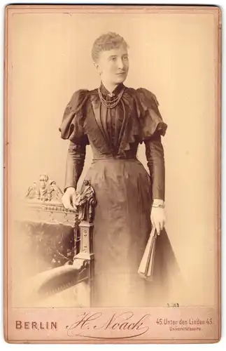 Fotografie H. Noack, Berlin, Unter den Linden 45, Frau im taillierten Kleid mit Fächer