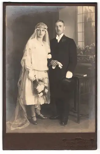 Fotografie Atelier Herold, Sayda /Erzgeb., Portrait junges Paar in Hochzeitskleidung mit Schleier und Blumenstrauss