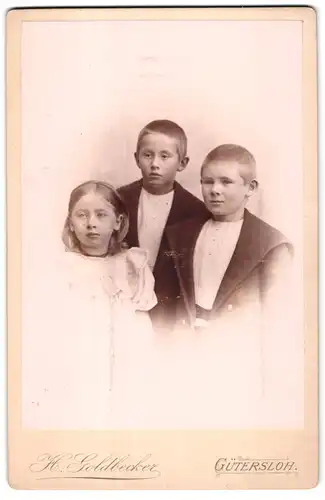 Fotografie H. Goldbecker, Gütersloh, Portrait kleines Mädchen und zwei Jungen in modischer Kleidung