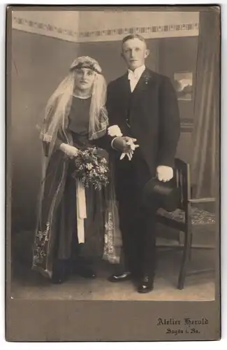 Fotografie Atelier Herold, Sayda i. Sa., Portrait junges Paar in Hochzeitskleidung mit Schleier und Blumenstrauss