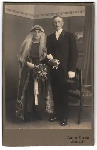 Fotografie Atelier Herold, Sayda i. Sa., Portrait junges Paar in Hochzeitskleidung mit Schleier und Blumenstrauss