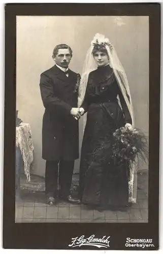 Fotografie J. Gg. Gmelch, Schongau /Oberbayern, Portrait junges Paar in Hochzeitskleidung mit Blumenstrauss