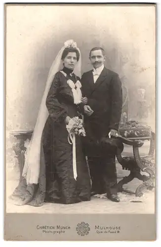 Fotografie Chrétien Munch, Mulhouse, Quai du Fossé 58, Portrait junges Paar in Hochzeitskleidung mit Blumenstrauss