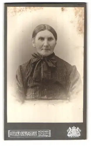 Fotografie M. Obergassner, München, Kaufingerstr. 14, Portrait betagte Dame mit Halstuch zur Schleife gebunden