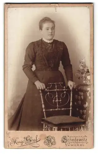 Fotografie Hugo Graf, Schedewitz, Portrait bildschönes Fräulein im Kleid am Stuhl stehend
