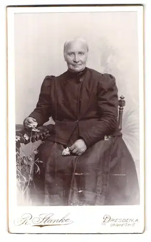 Fotografie R. Stanke, Dresden-A., Uhlandstr. 6, Portrait betagte Dame im prachtvollen Kleid und Blume in der Hand