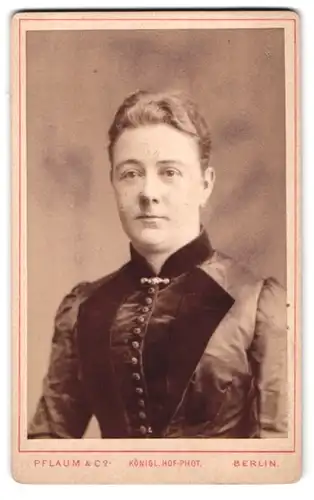 Fotografie Pflaum & Co., Berlin, Königsstr. 57, Portrait hübsche Dame mit Brosche am Kleiderkragen