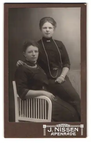 Fotografie J. Nissen, Apenrade, Portrait zwei hübsche junge Damen in eleganten Kleidern