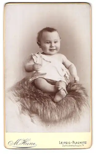 Fotografie M. Heine, Leipzig-Plagwitz, Zschocherschestr. 7b, Portrait lachendes Baby auf einem Fell