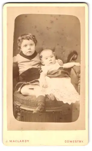 Fotografie J. Maclardy, Oswestry, Church Street, niedliches Kind mit Baby auf Sessel posierend