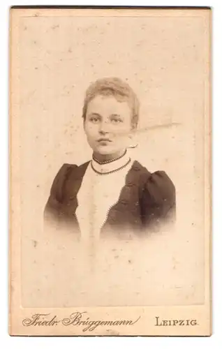 Fotografie Friedr. Brüggemann, Leipzig, Eisenbahn-Str. 1, Hübsche junge Frau mit lockigem Haar im traditionellem Kleid