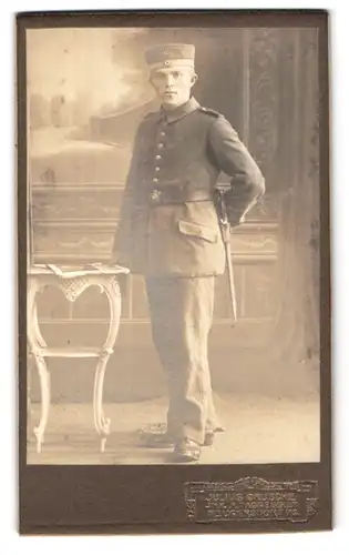 Fotografie Julius Grusche, Neugersdorf, Portrait junger Soldat in Felduniform, Bajonett am Koppel