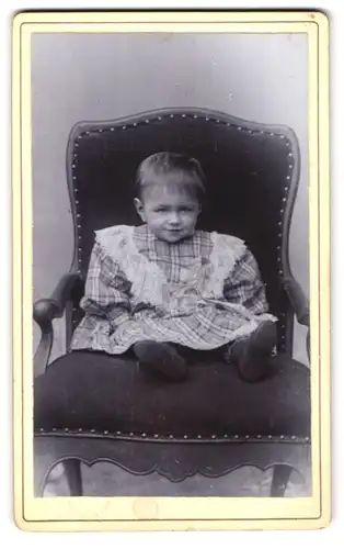 Fotografie Louis Uhle, Siebenleben-Gotha, kleines grinsendes Kind auf Lehnstuhl sitzend