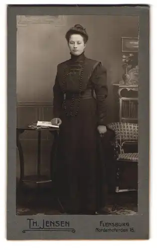 Fotografie Th. Jensen, Flensburg, Norderhofenden 15, Dame im schwarzen kleid in einer Studiokulisse