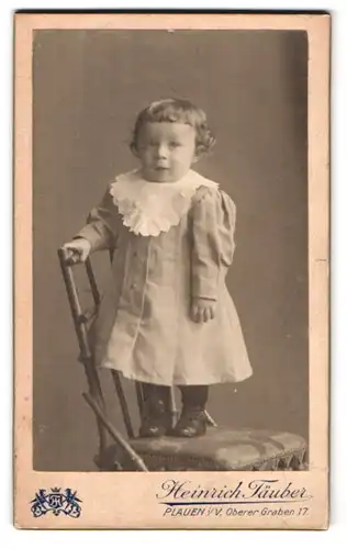 Fotografie Heinrich Täuber, Plauen / Vogtland, Oberer-Graben 17, Kleines Mädchen im Kleid auf einem Stuhl
