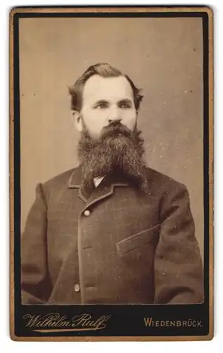 Fotografie Wilhelm Rulf, Wiedenbrück, Portrait modisch frisierter Mann mit gezwirbelten Vollbart