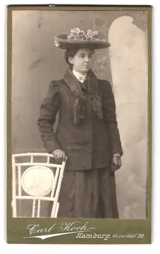 Fotografie Carl Koch, Hamburg, Neuer Wall 30, Portrait junge Frau im Kleid mit Pelzkragen und breitkrempigen Hut