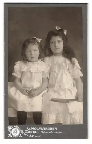 Fotografie G. Wolfsgruber, Aarau, Bahnhofstr., Geschwister im weissen Kleid mit weisser Schleife im Haar