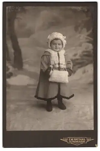 Fotografie E.W. Matthias, Seifhennersdorf, Portrait niedliches Mädchen im Mantel mit Handwärmer
