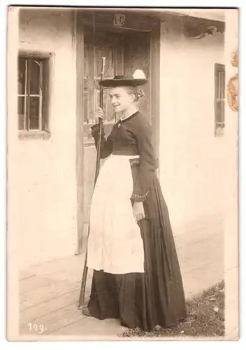 Fotografie unbekannter Fotograf und Ort, Portrait junge Frau in Tracht mit Hut und Stock