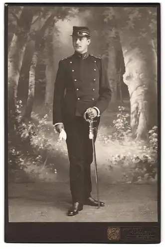 Fotografie Alfred Kugler, Basel, Portrait Artillerist in Uniform mit Degen vor einer Studiokulisse