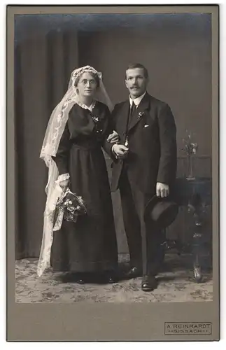 Fotografie A. Reinhardt, Sissach, Portrait Hochzeitsfoto im schwarzen Kleid mit weissem Schleier, Mann mit Zylinder