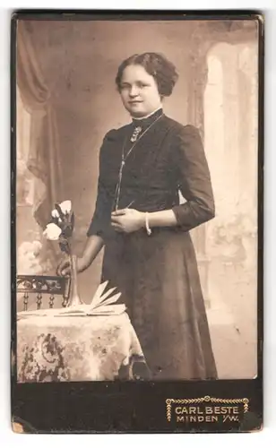 Fotografie Carl Beste, Minden / W., Bäckerstr. 13, Hübsche Frau im Kleid mit Armband und Buch