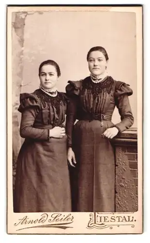 Fotografie Arnold Seiler, Liestal, Portrait zwei bildschöne junge Frauen in elegant bestickten Kleidern