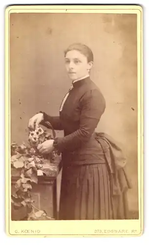 Fotografie C. Koenig, Paddington, 373 Edgware Rd., Portrait schönes Fräulein im gerüschten Kleid mit Blumenkorb