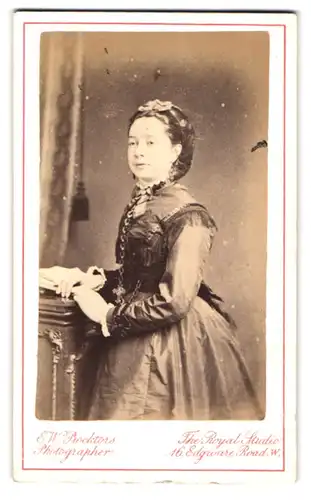 Fotografie E. W. Proktor, London, Edgware Road, Portrait elegant gekleidete Dame mit Haarschleife